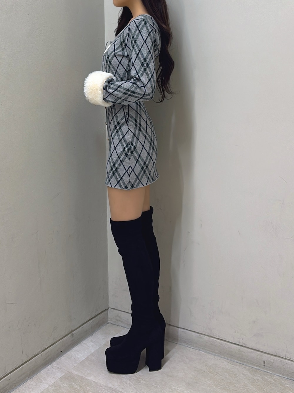 グレー系のワンピース、ブラック系のブーツを着用したレディースの秋コーディネートの2枚目の写真