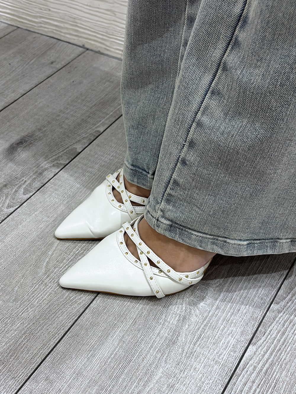 ホワイト系のシャツ/ブラウス、ブルー系のデニムパンツ、ホワイト系のパンプスを着用したレディースの冬コーディネートの5枚目の写真