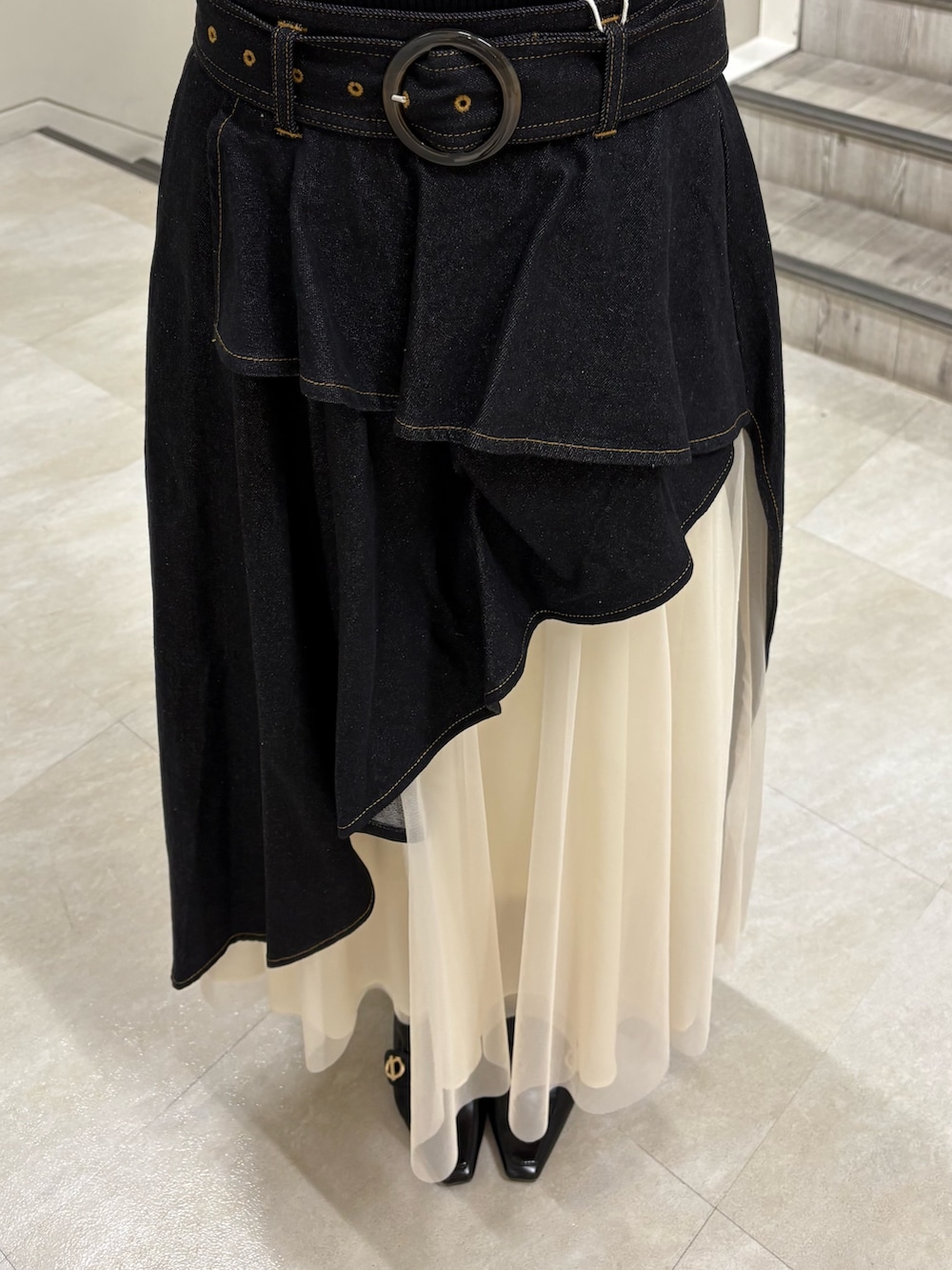 ブラック系のニット/セーター、ブラック系のスカート、ブラック系のパンプスを着用したレディースの春コーディネートの4枚目の写真