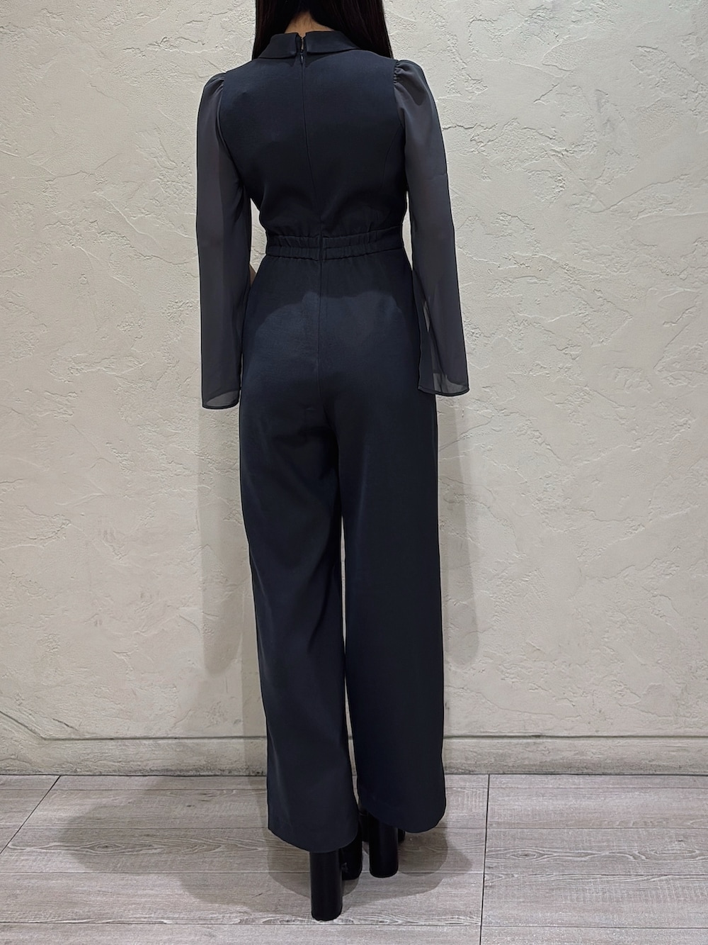 グレー系のワンピース、ブラック系のブーツを着用したレディースの冬コーディネートの3枚目の写真