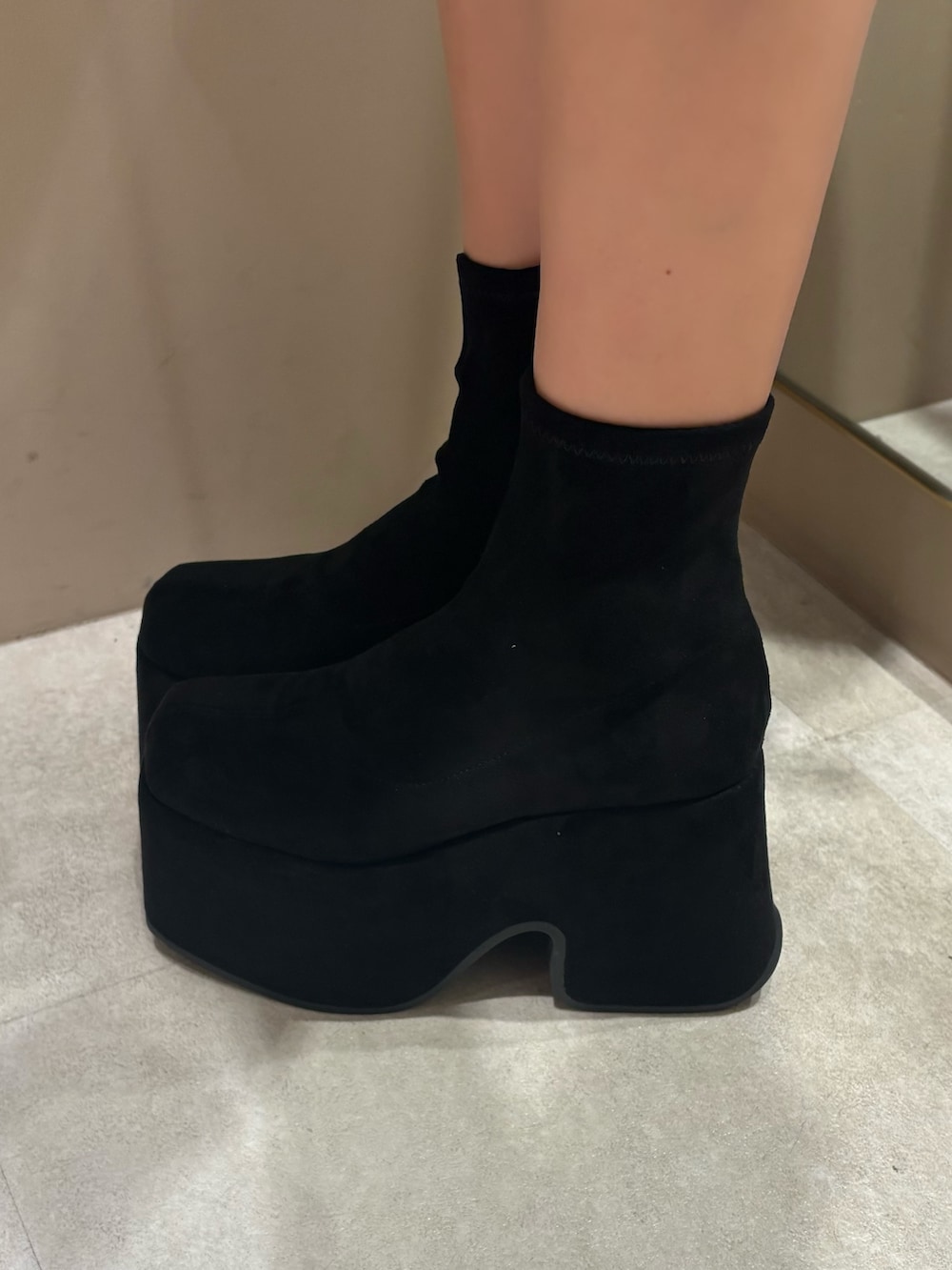 ベージュ系のワンピース、ピンク系のボストンバッグ、ブラック系のブーツを着用したレディースの冬コーディネートの5枚目の写真