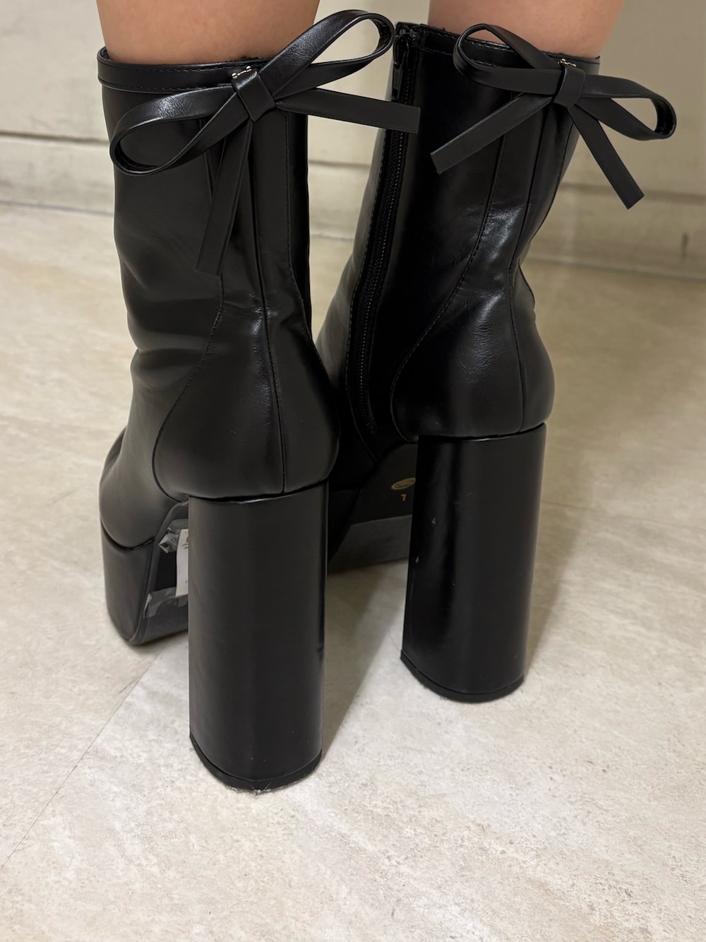 ブラック系のワンピース、ブラック系のブーツ、ブラック系のハンドバッグを着用したレディースの春コーディネートの5枚目の写真