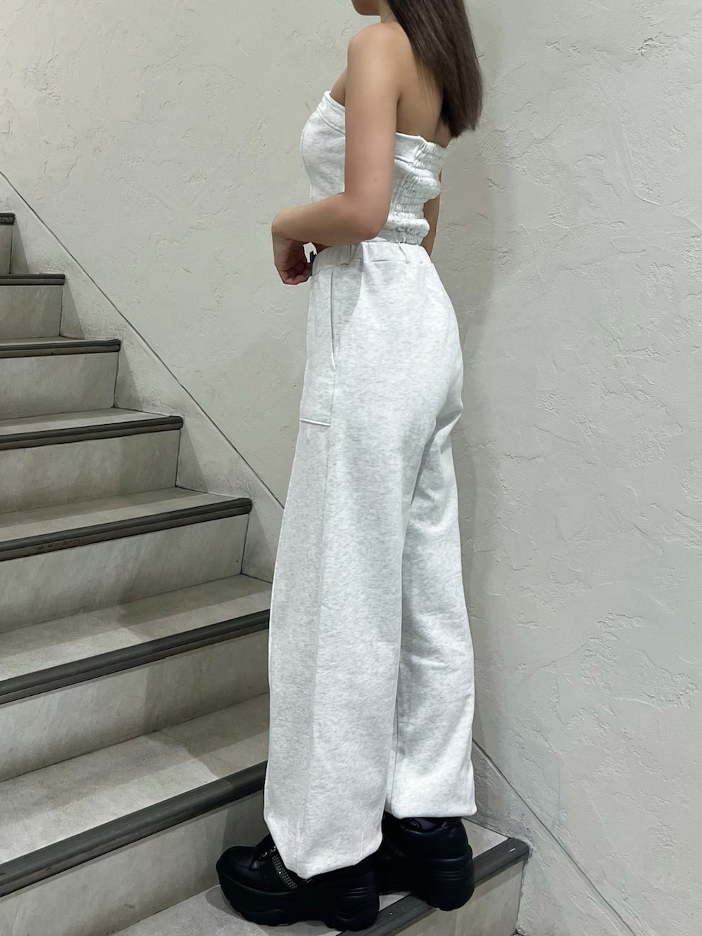 グレー系のキャミソール、グレー系のスウェットパンツ、ブラック系のスニーカーを着用したレディースの夏コーディネートの2枚目の写真