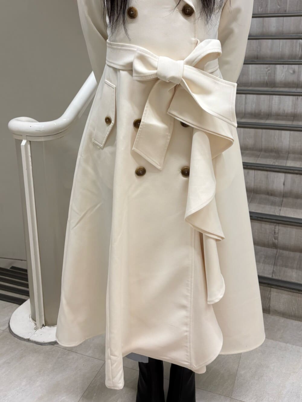 ブラック系のブーツ、ホワイト系のトレンチコートを着用したレディースの冬コーディネートの4枚目の写真