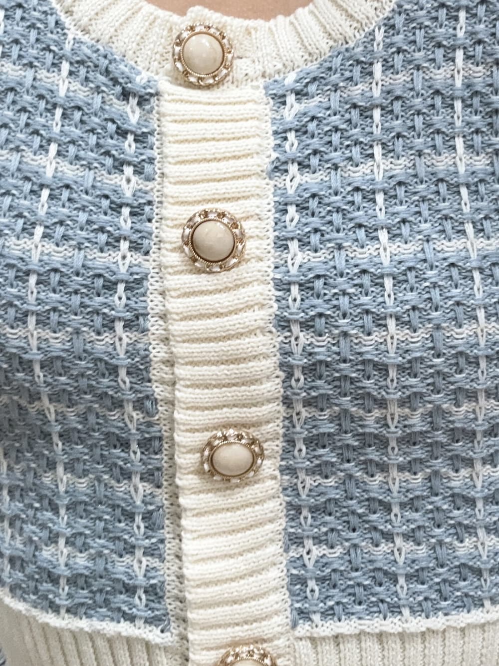 ブルー系のニット/セーター、ブルー系のデニムパンツ、ホワイト系のサンダルを着用したレディースの春コーディネートの4枚目の写真