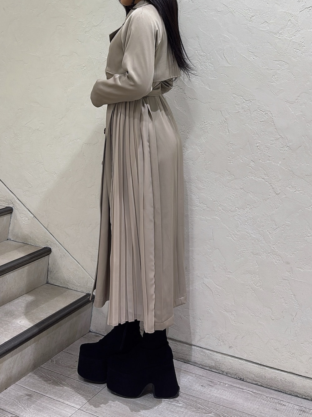 ベージュ系のトレンチコート、ブラック系のブーツを着用したレディースの冬コーディネートの2枚目の写真