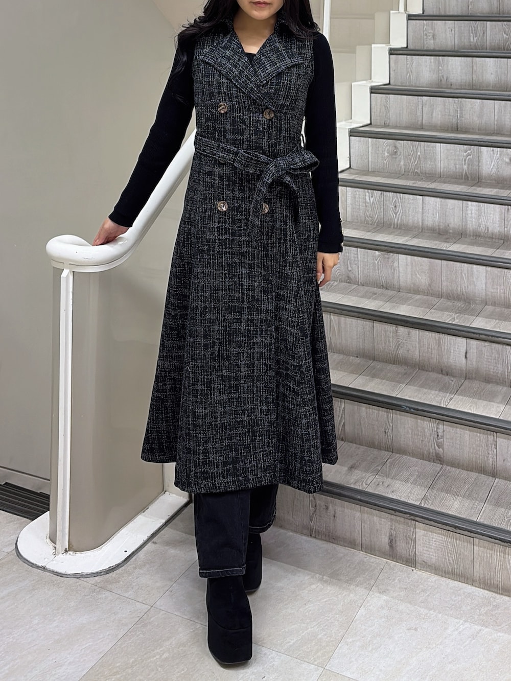 ブラック系のトレンチコート、ブラック系のブーツを着用したレディースの冬コーディネートの4枚目の写真