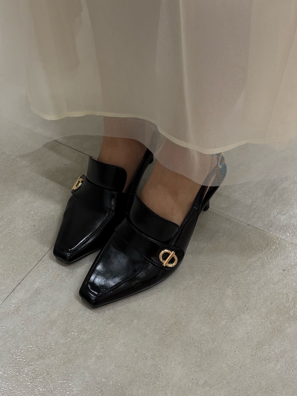 ブラック系のニット/セーター、ブラック系のスカート、ブラック系のパンプスを着用したレディースの春コーディネートの5枚目の写真