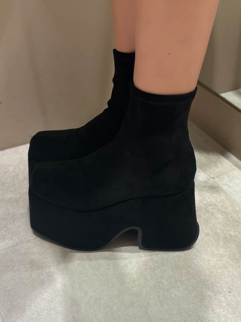 ベージュ系のトレンチコート、ブラック系のブーツを着用したレディースの冬コーディネートの5枚目の写真