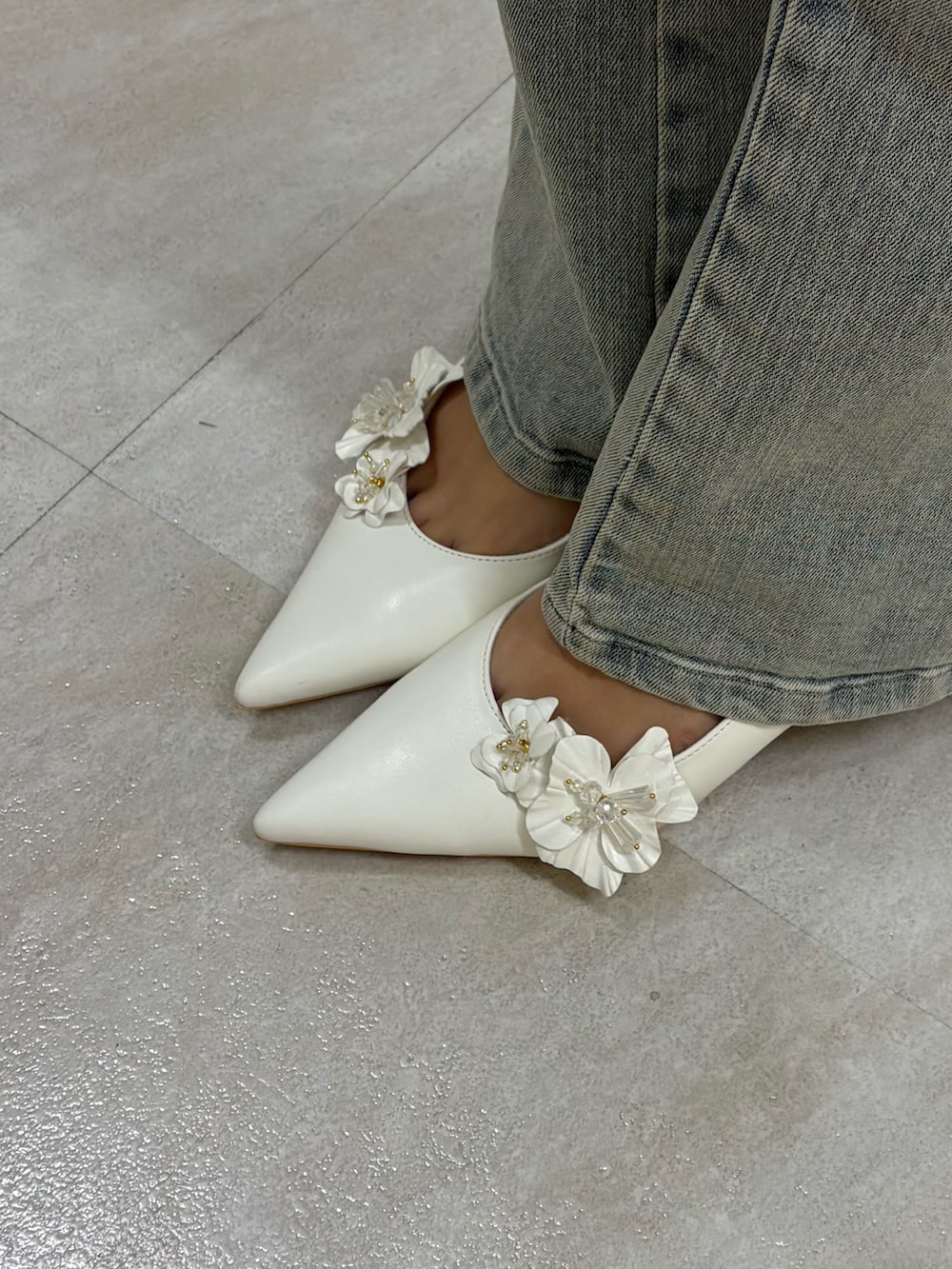 グレー系のその他アウター、ブルー系のデニムパンツ、ホワイト系のパンプスを着用したレディースの春コーディネートの5枚目の写真