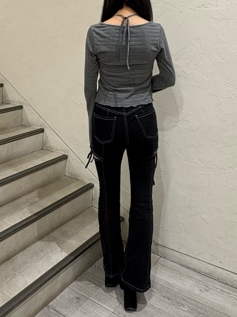 グレー系のTシャツ/カットソー、ブラック系のデニムパンツ、ブラック系のブーツを着用したレディースの秋コーディネートの3枚目の写真