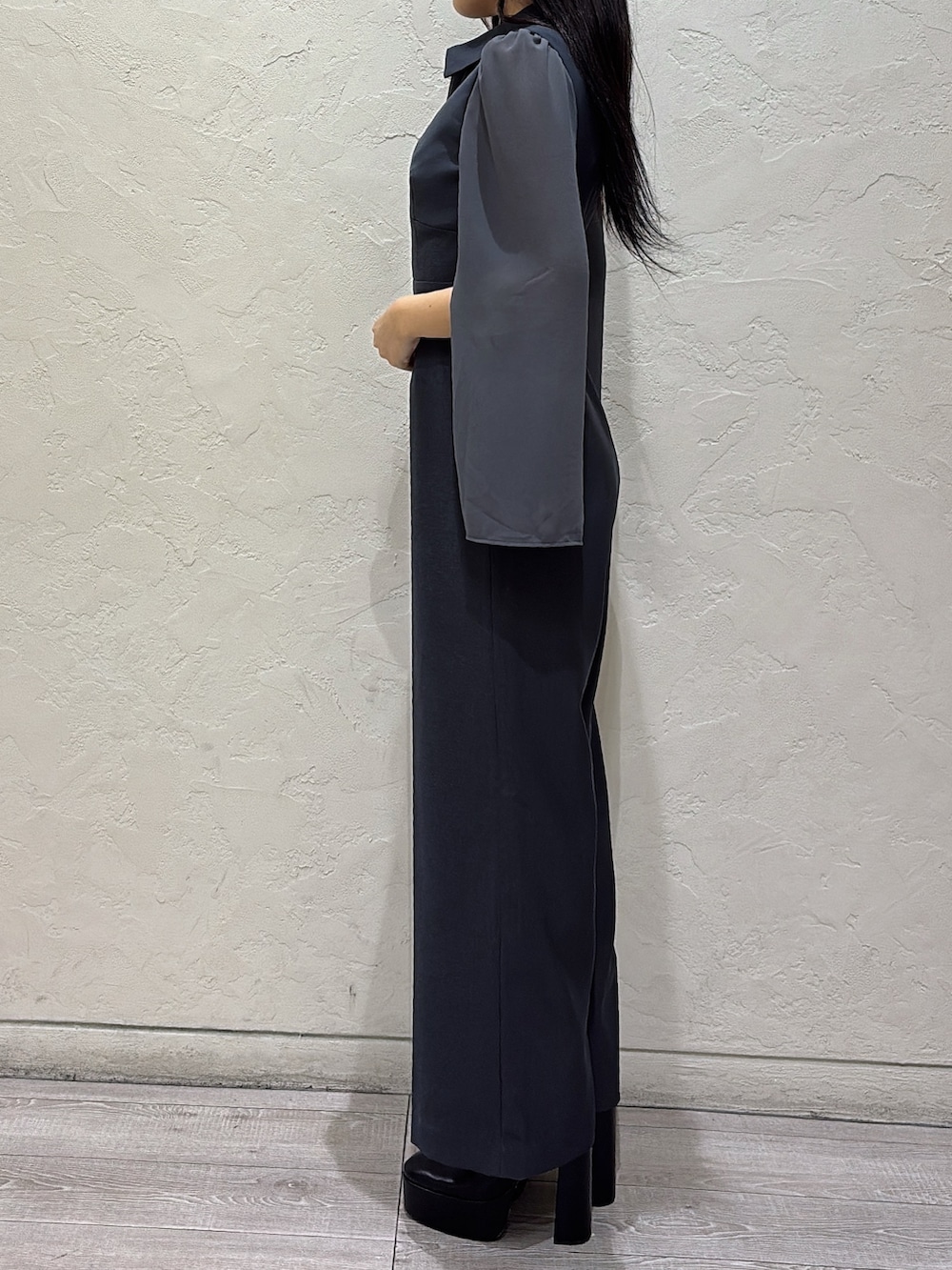 グレー系のワンピース、ブラック系のブーツを着用したレディースの冬コーディネートの2枚目の写真