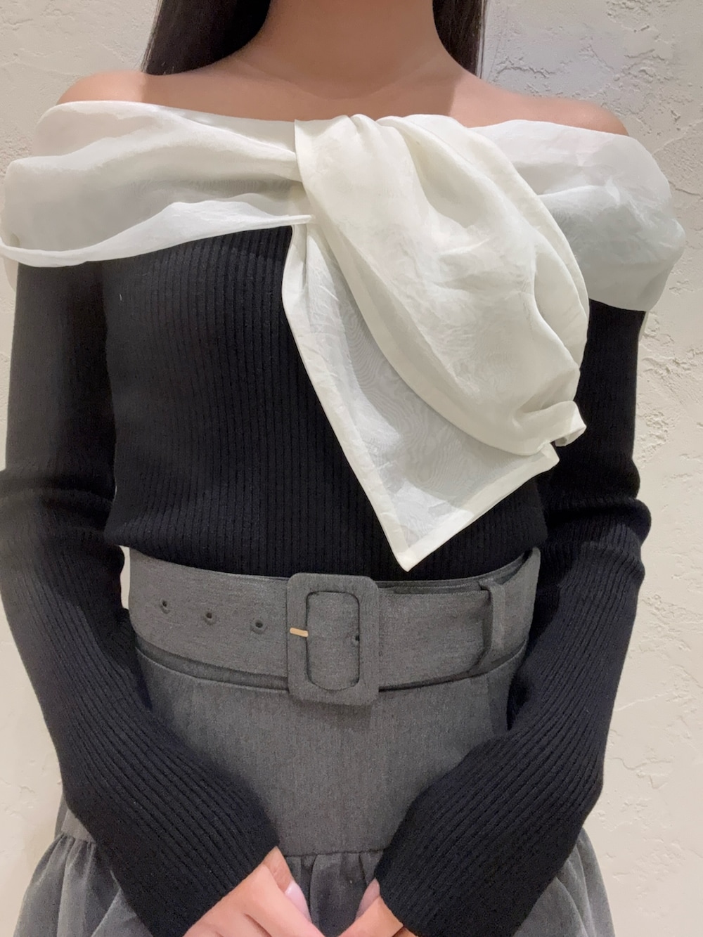 ブラック系のニット/セーター、グレー系のスカート、ブラック系のブーツを着用したレディースの春コーディネートの4枚目の写真