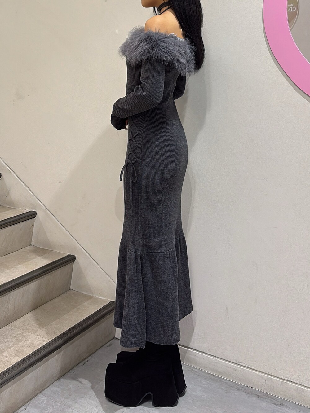 グレー系のワンピース、ブラック系のブーツを着用したレディースの秋コーディネートの2枚目の写真