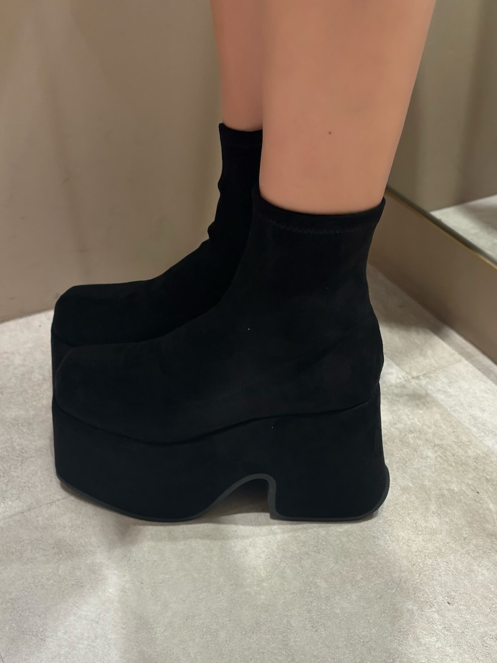 ブラック系のTシャツ/カットソー、ブルー系のテーラードジャケット、ブラック系のスカートを着用したレディースの春コーディネートの5枚目の写真