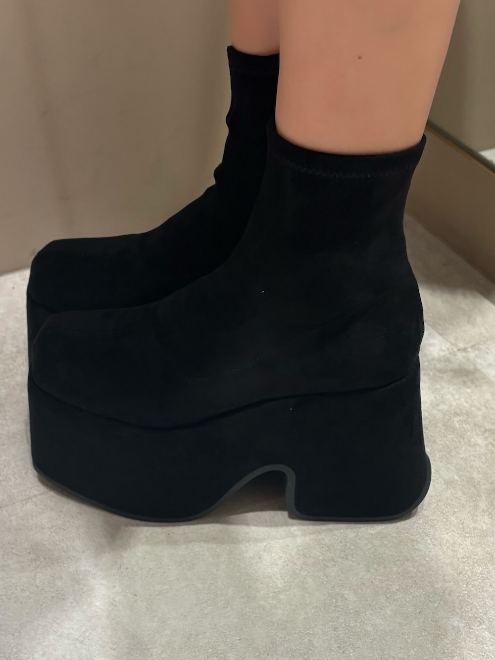 ホワイト系のワンピース、ブラック系のブーツを着用したレディースの春コーディネートの5枚目の写真