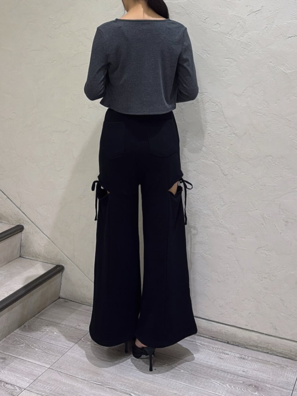 ブラック系のパンプス、グレー系のカーディガン/ボレロ、ブラック系のスウェットパンツを着用したレディースの夏コーディネートの3枚目の写真