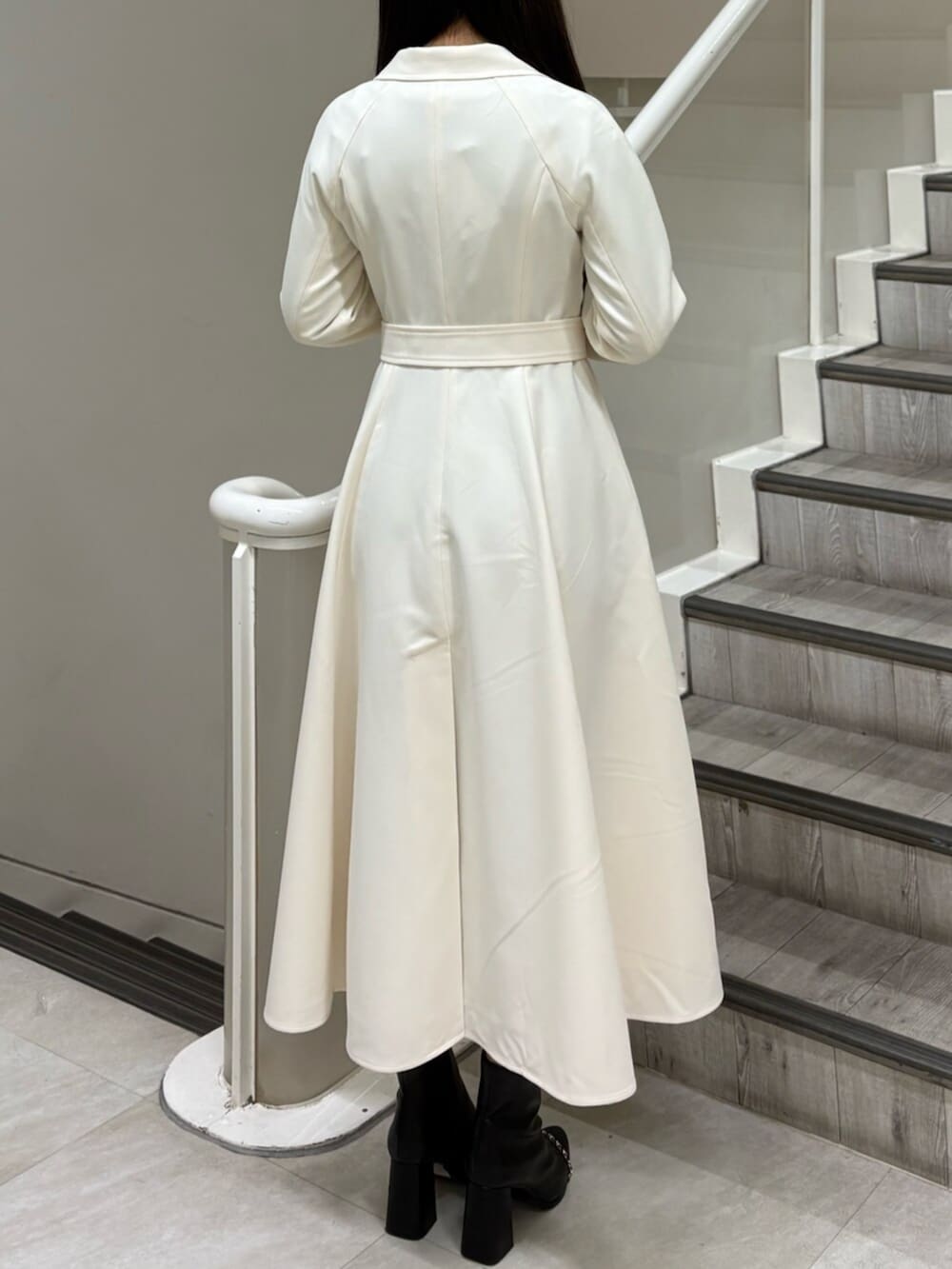 ブラック系のブーツ、ホワイト系のトレンチコートを着用したレディースの冬コーディネートの3枚目の写真