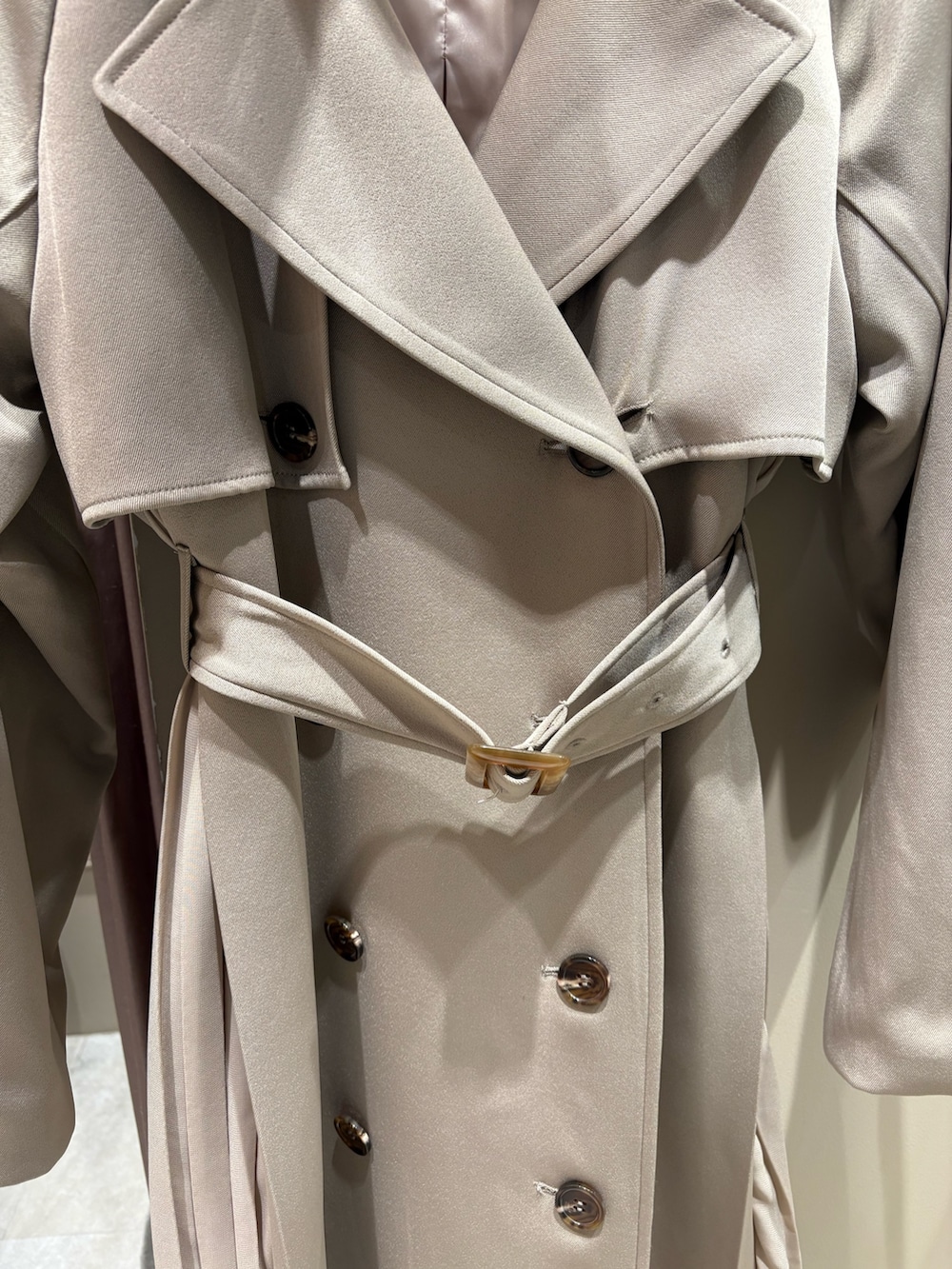 ベージュ系のトレンチコート、ブラック系のブーツを着用したレディースの冬コーディネートの4枚目の写真