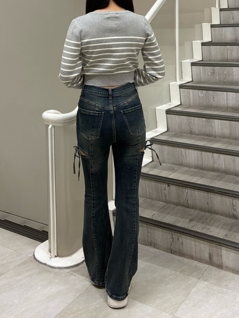 グレー系のカーディガン/ボレロ、ブルー系のデニムパンツを着用したレディースの春コーディネートの3枚目の写真