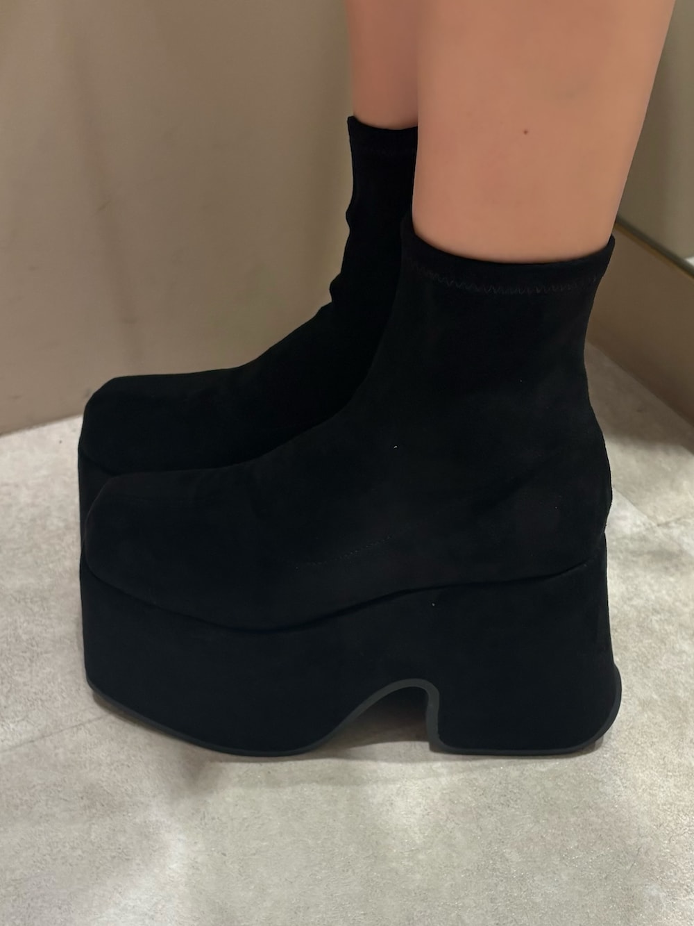 グレー系のスウェット、ブルー系のデニムパンツ、ブラック系のブーツを着用したレディースの冬コーディネートの5枚目の写真