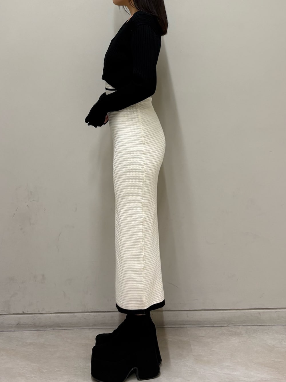 ホワイト系のワンピース、ブラック系のブーツを着用したレディースの春コーディネートの2枚目の写真