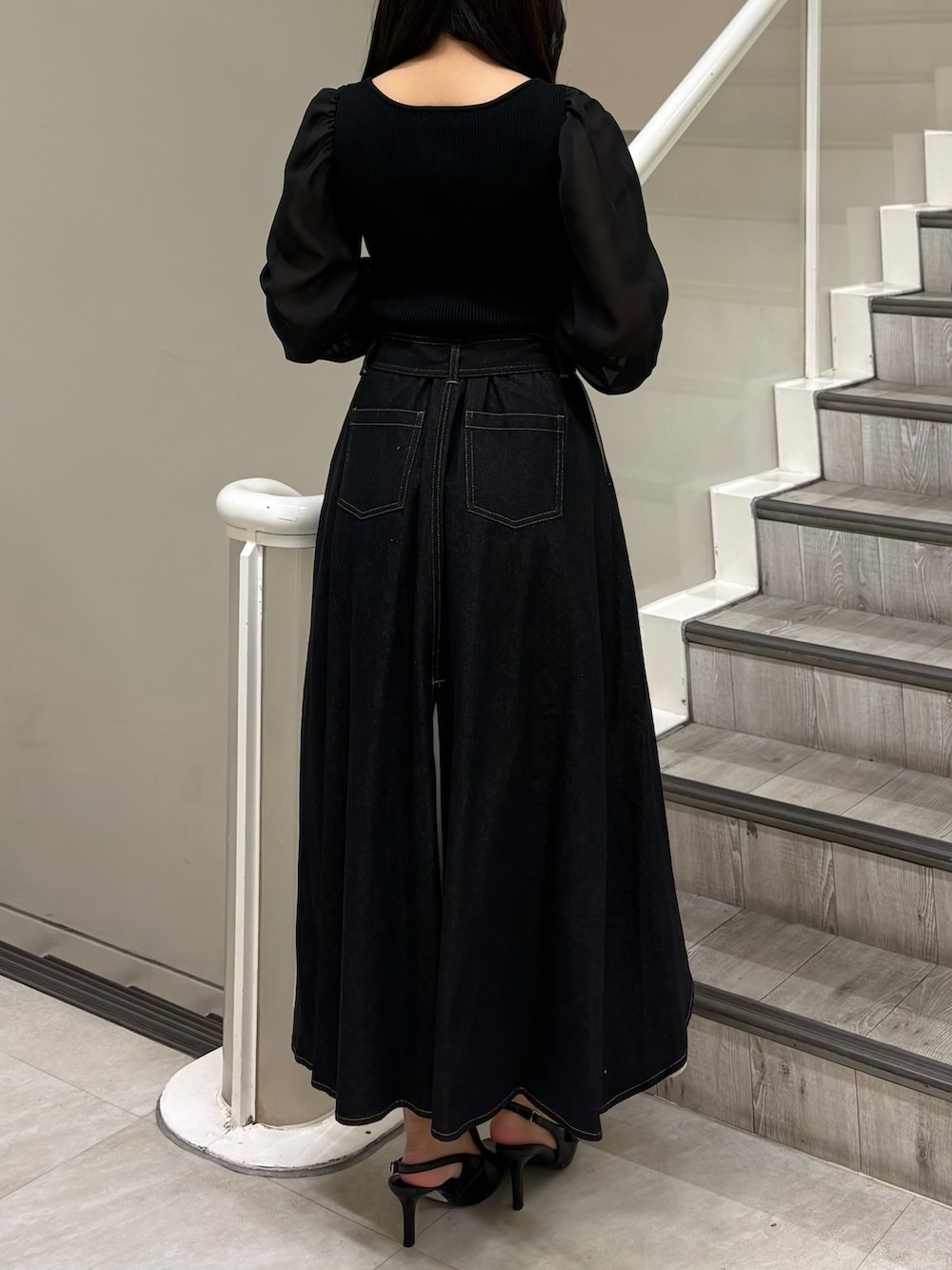 ブラック系のニット/セーター、ブラック系のスカート、ブラック系のパンプスを着用したレディースの春コーディネートの3枚目の写真