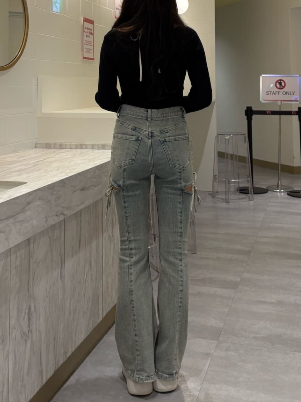 ブラック系のニット/セーター、ブルー系のデニムパンツ、ブラック系のキャップを着用したレディースの冬コーディネートの3枚目の写真