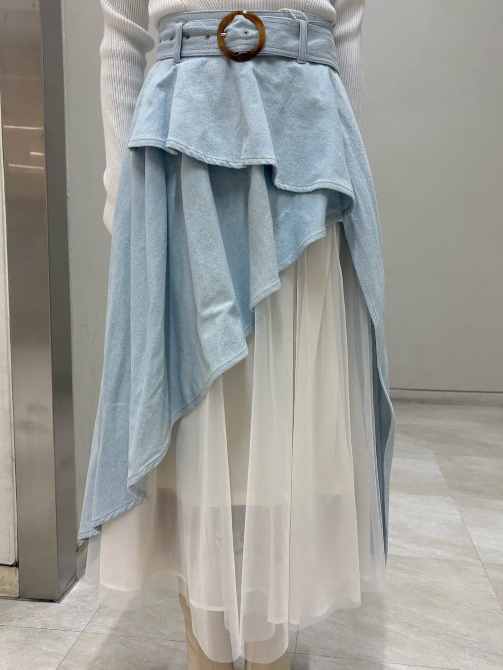 ホワイト系のニット/セーター、ブルー系のスカート、ホワイト系のブーツを着用したレディースの春コーディネートの4枚目の写真