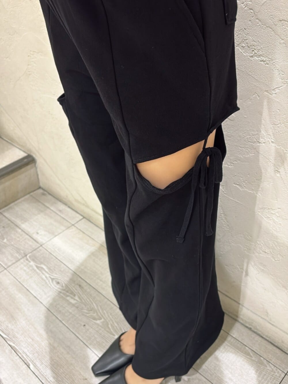ブラック系のパンプス、グレー系のカーディガン/ボレロ、ブラック系のスウェットパンツを着用したレディースの夏コーディネートの5枚目の写真