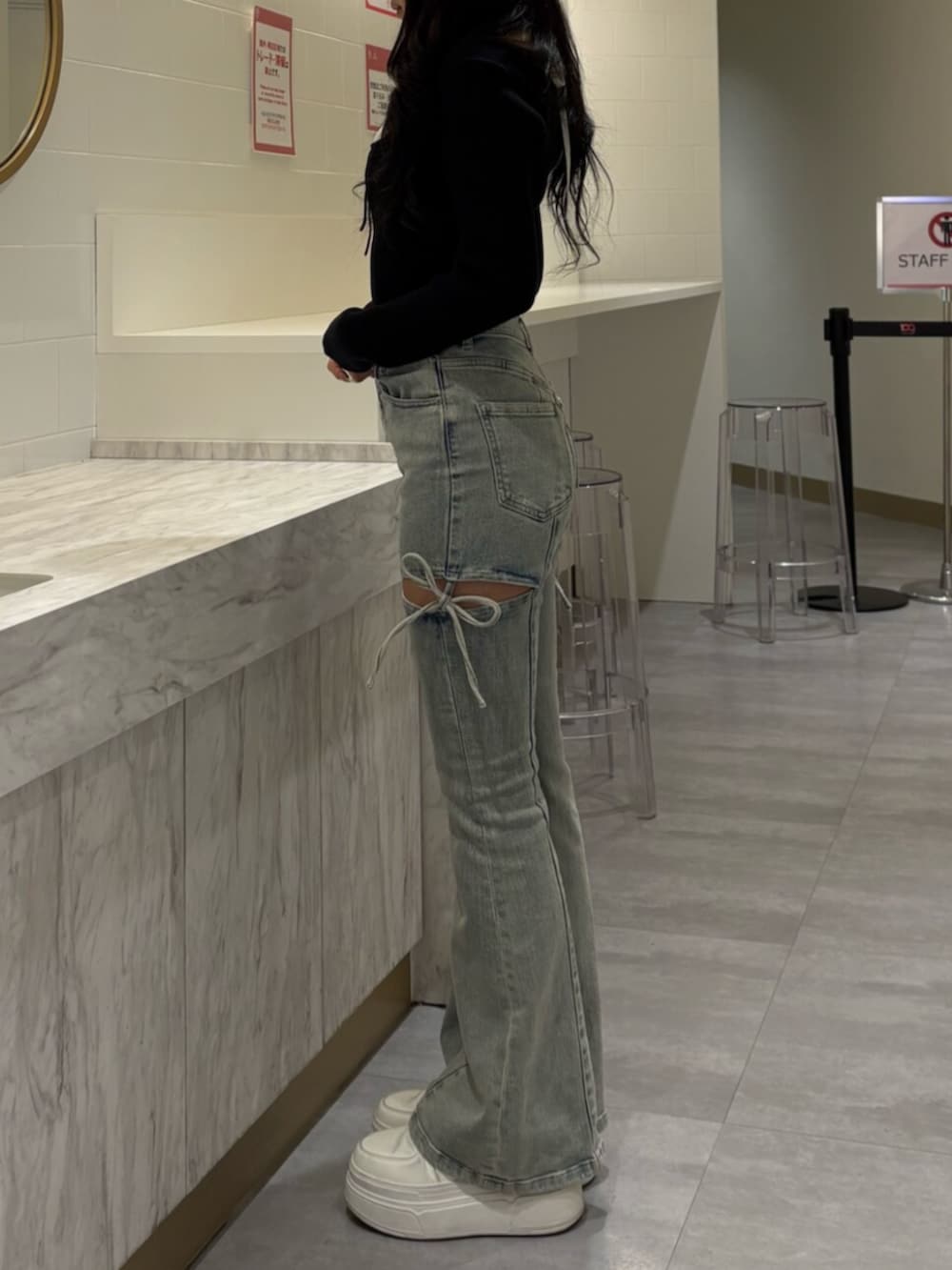 ブラック系のニット/セーター、ブルー系のデニムパンツ、ブラック系のキャップを着用したレディースの冬コーディネートの2枚目の写真