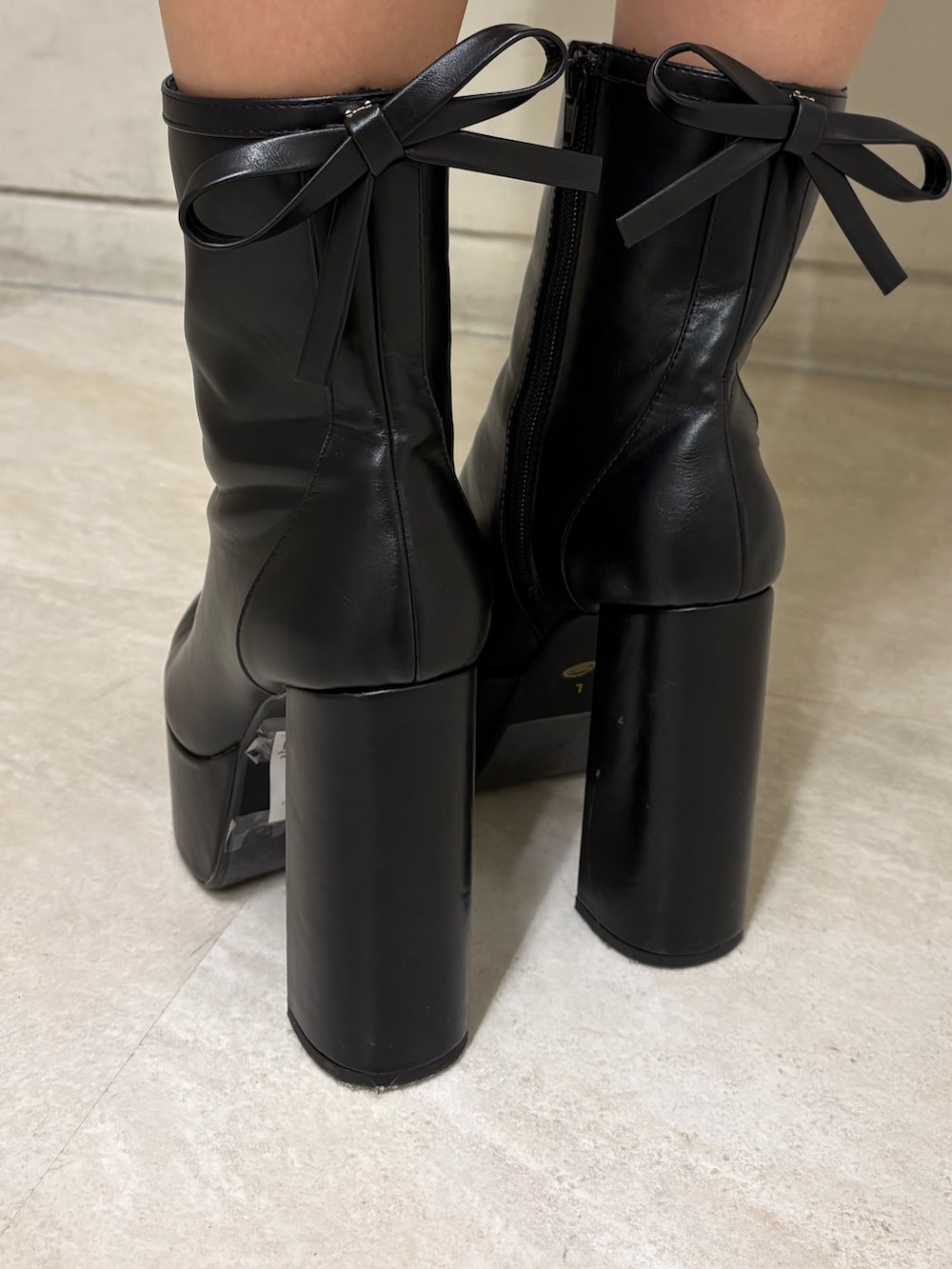 ピンク系のワンピース、ブラック系のブーツを着用したレディースの春コーディネートの5枚目の写真