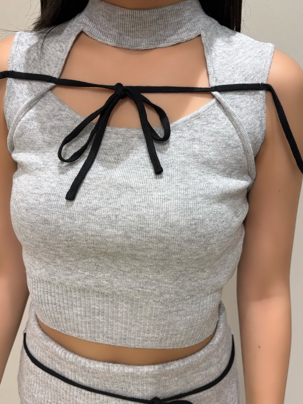 グレー系のニット/セーター、グレー系のスカート、ブラック系のサンダルを着用したレディースの夏コーディネートの4枚目の写真