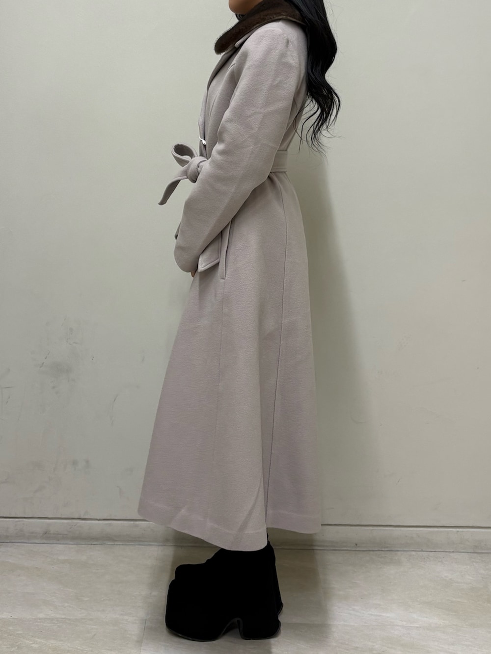 ベージュ系のその他アウター、ブラック系のブーツ、ブラウン系のハンドバッグを着用したレディースの冬コーディネートの2枚目の写真