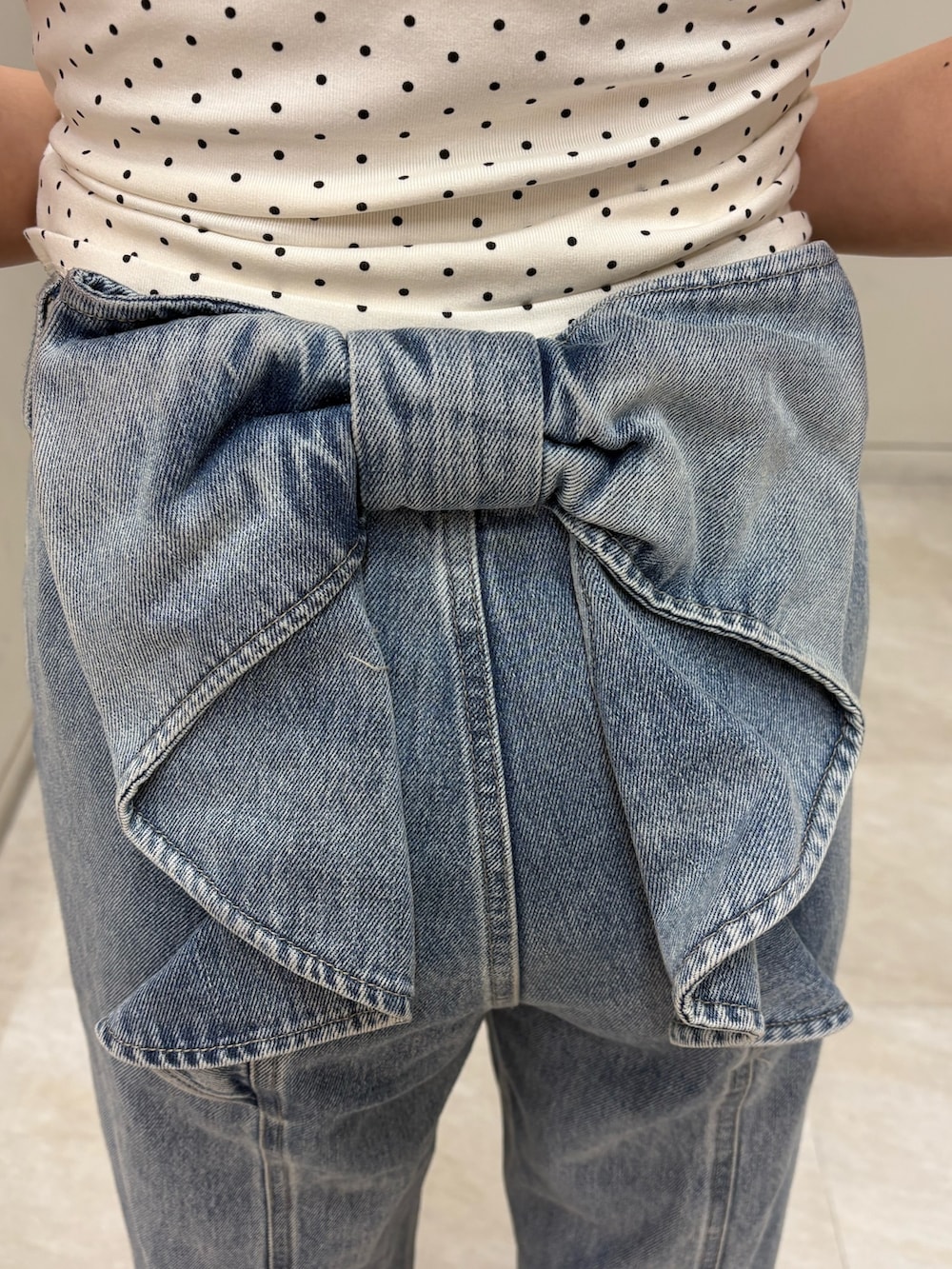 ホワイト系のTシャツ/カットソー、ブルー系のデニムパンツ、ホワイト系のサンダルを着用したレディースの夏コーディネートの5枚目の写真