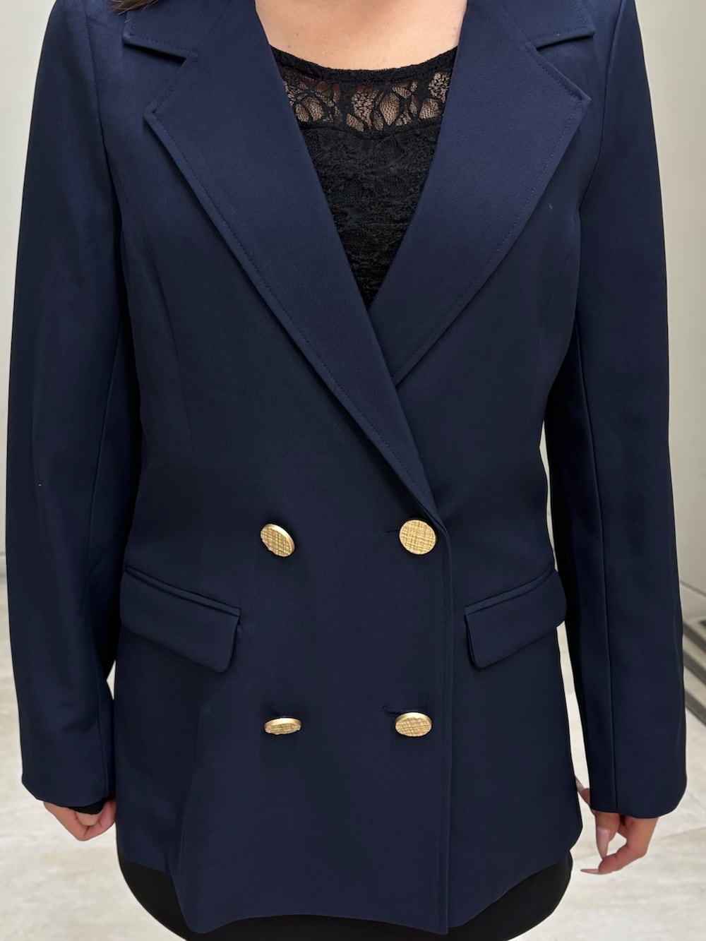 ブラック系のTシャツ/カットソー、ブルー系のテーラードジャケット、ブラック系のスカートを着用したレディースの春コーディネートの4枚目の写真