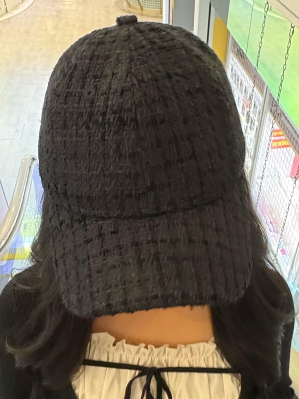 ブラック系のニット/セーター、ブルー系のデニムパンツ、ブラック系のキャップを着用したレディースの冬コーディネートの5枚目の写真