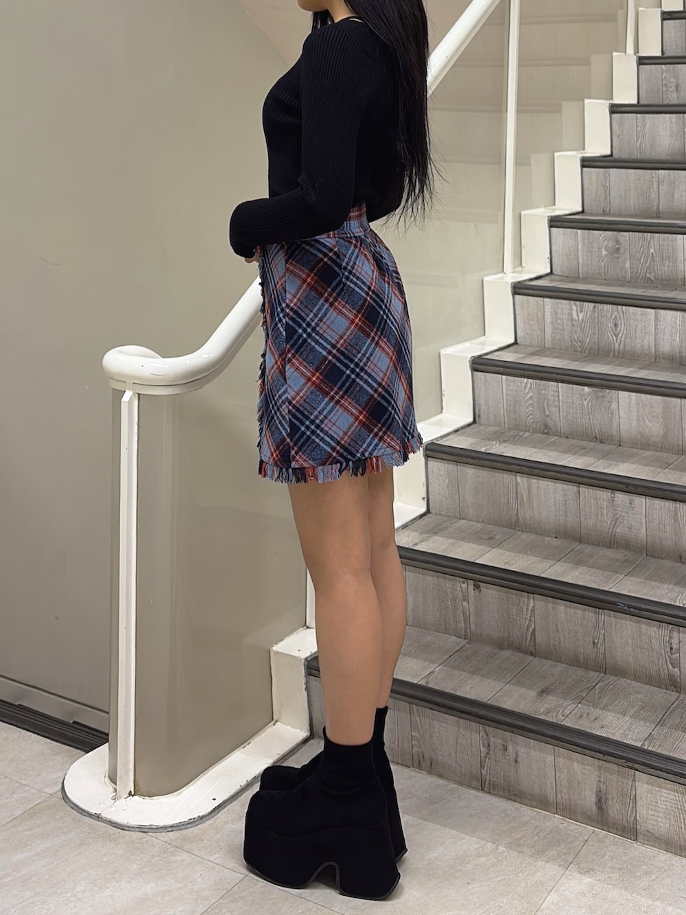 ブラック系のブルゾン、ブルー系のスカート、ブラック系のニット/セーターを着用したレディースの冬コーディネートの4枚目の写真