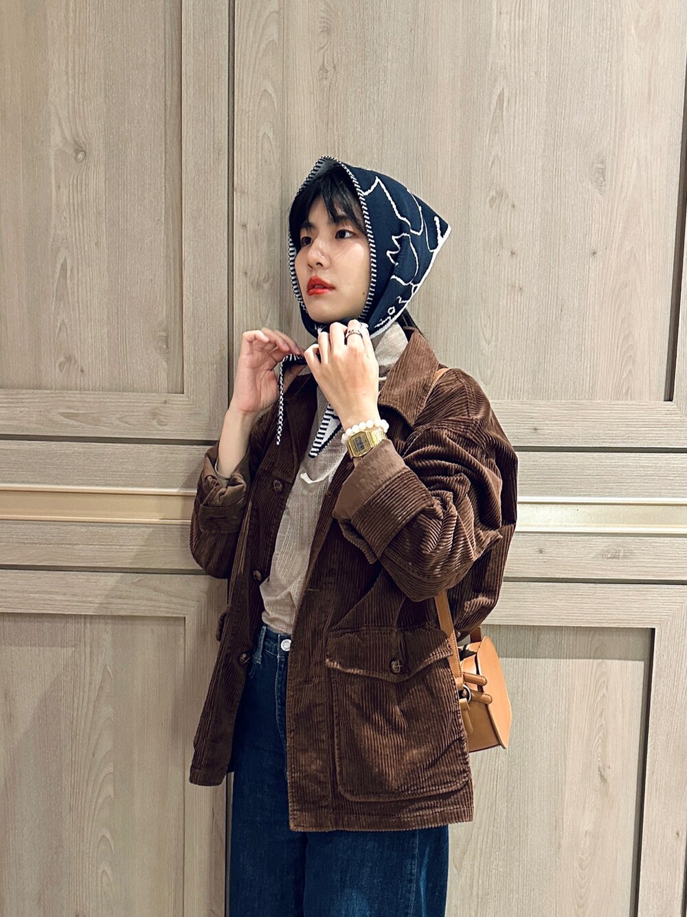 ベージュ系のトップス、ブラック系のブルゾン、ブルー系のデニムパンツを着用したレディースの冬コーディネートの2枚目の写真