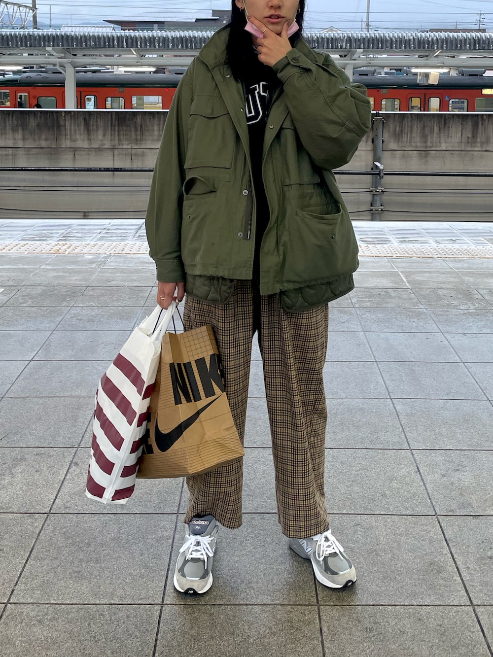 グリーン系のブルゾン、ブラウン系のパンツ、グレー系のスニーカーを着用したレディースの冬コーディネートの2枚目の写真