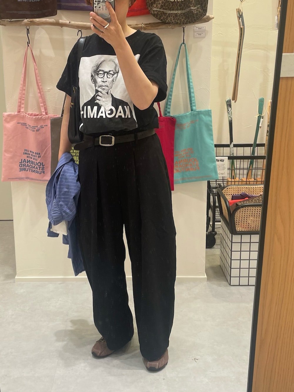 ブラック系のパンツ、ブラウン系のスニーカー、ブラック系のTシャツ/カットソーを着用したレディースの秋コーディネートの2枚目の写真