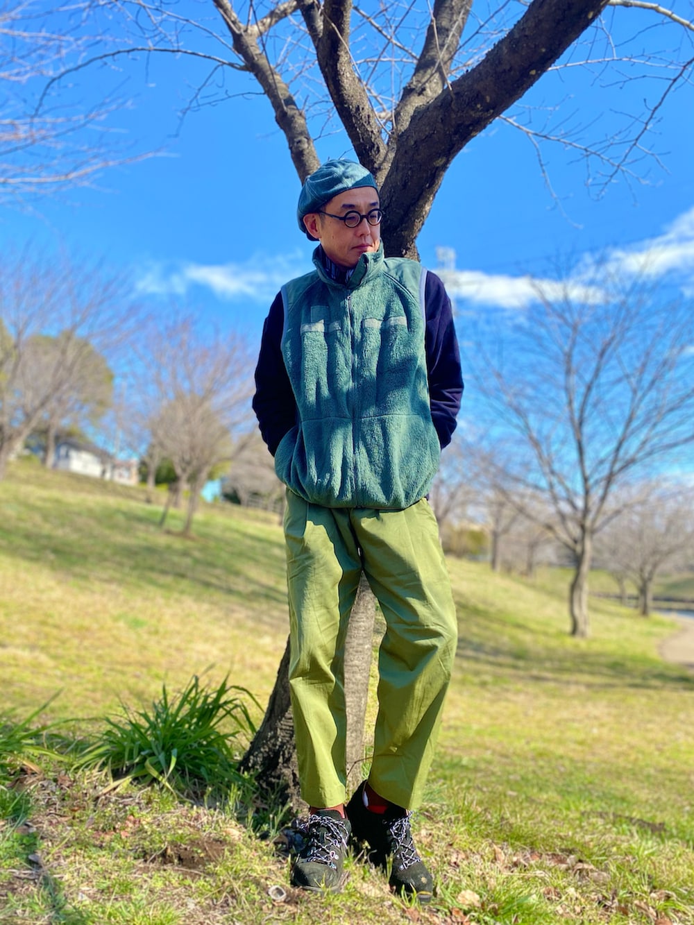 グレー系のベスト、グリーン系のチノパンツ、ブラック系のスウェットを着用したメンズの冬コーディネートの2枚目の写真