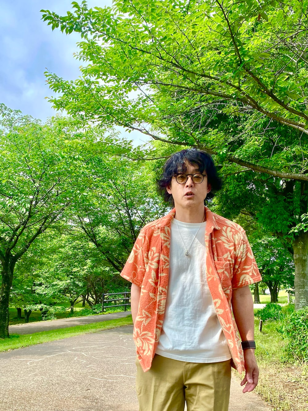 ベージュ系のチノパンツ、オレンジ系のシャツ/ブラウス、ホワイト系のTシャツ/カットソーを着用したメンズの夏コーディネートの5枚目の写真