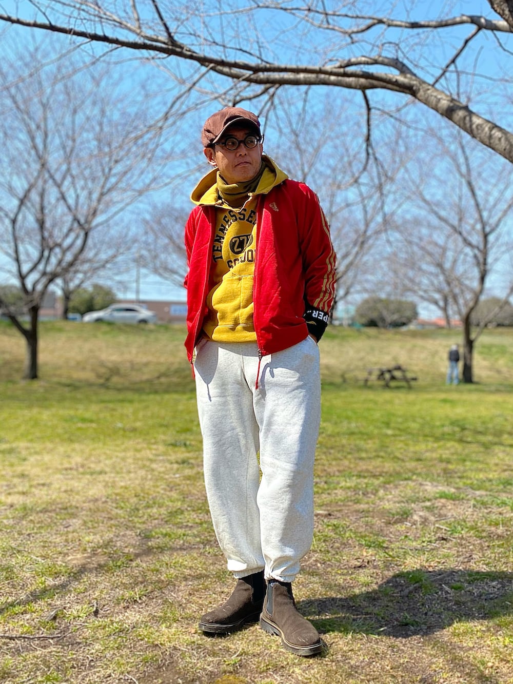 レッド系のジャージ、ホワイト系のスウェットパンツ、ブラウン系のブーツを着用したメンズの春コーディネートの3枚目の写真