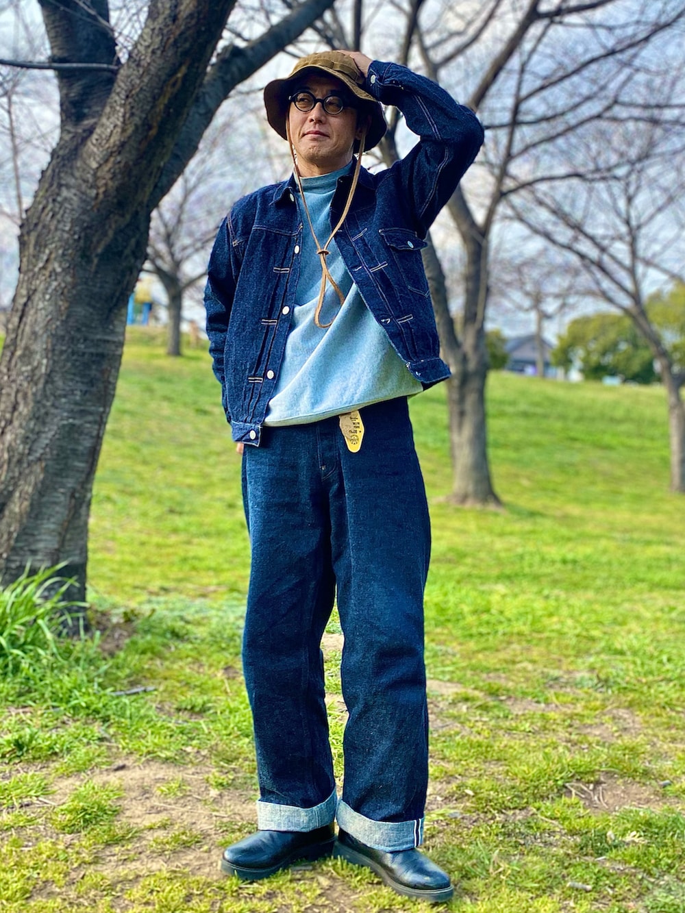 ブルー系のデニムジャケット、グレー系のスウェット、ブルー系のデニムパンツを着用したメンズの春コーディネートの3枚目の写真