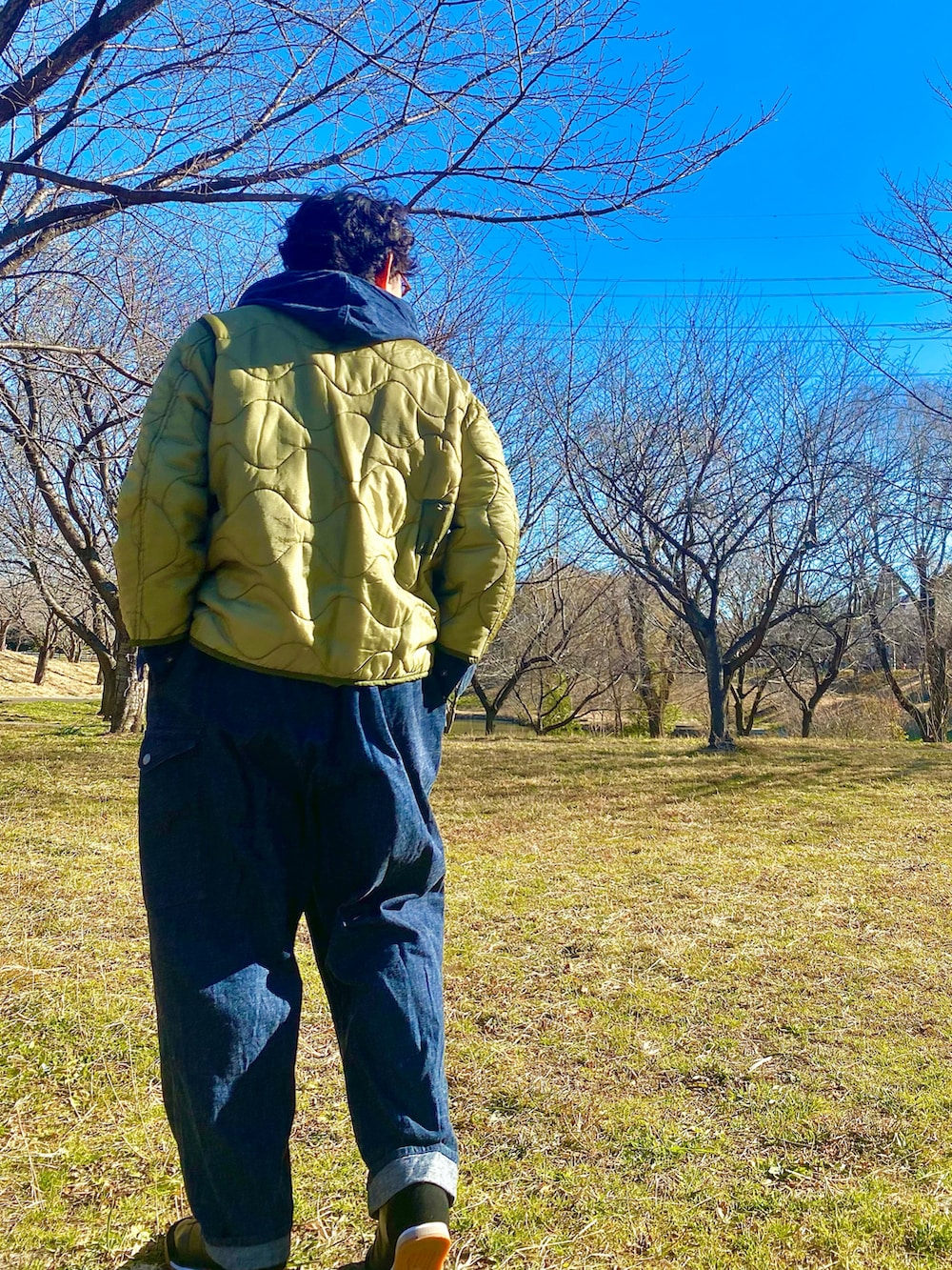 ブルー系のカバーオール、グリーン系のミリタリージャケットを着用したメンズの冬コーディネートの2枚目の写真