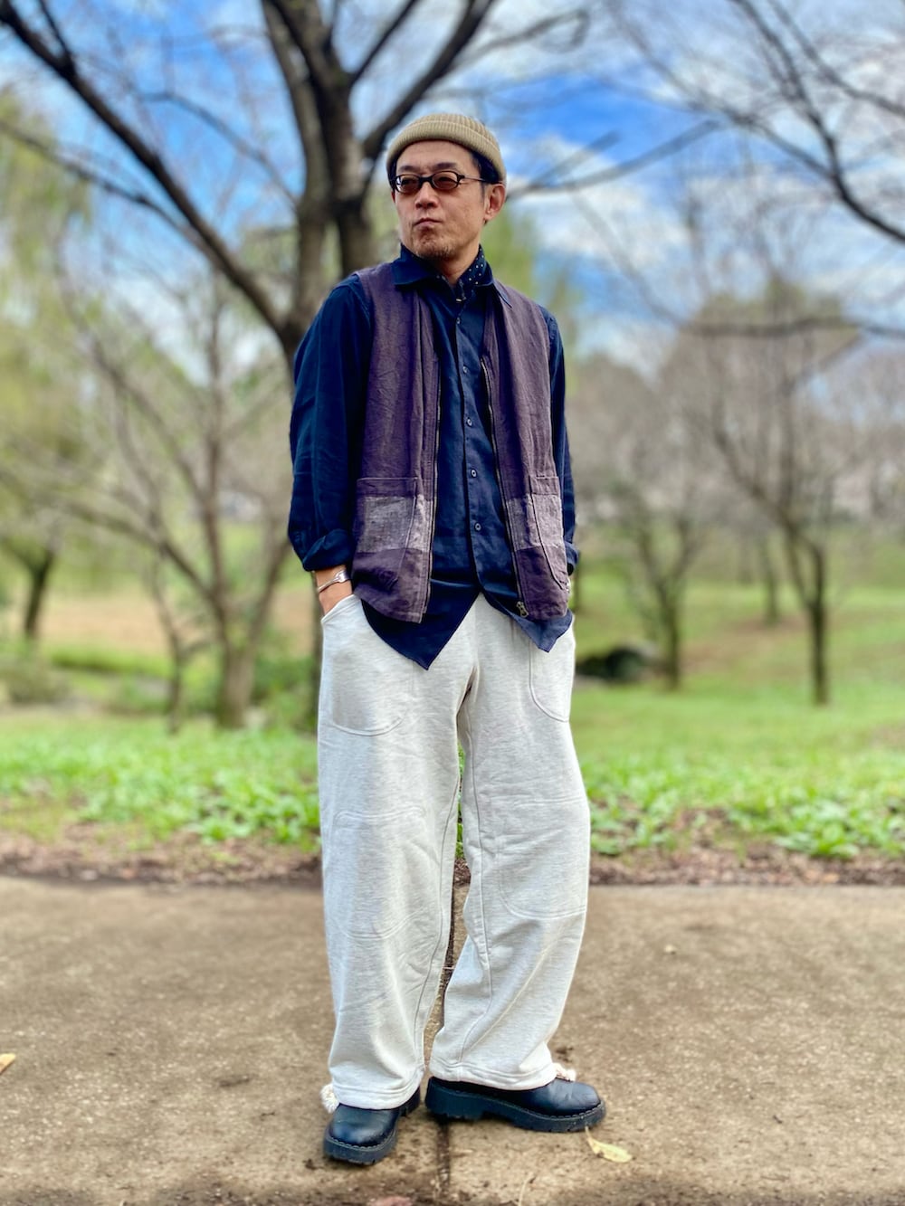 ホワイト系のスウェットパンツ、ブラック系のベスト、ホワイト系のニットキャップ/ビーニーを着用したメンズの秋コーディネートの2枚目の写真