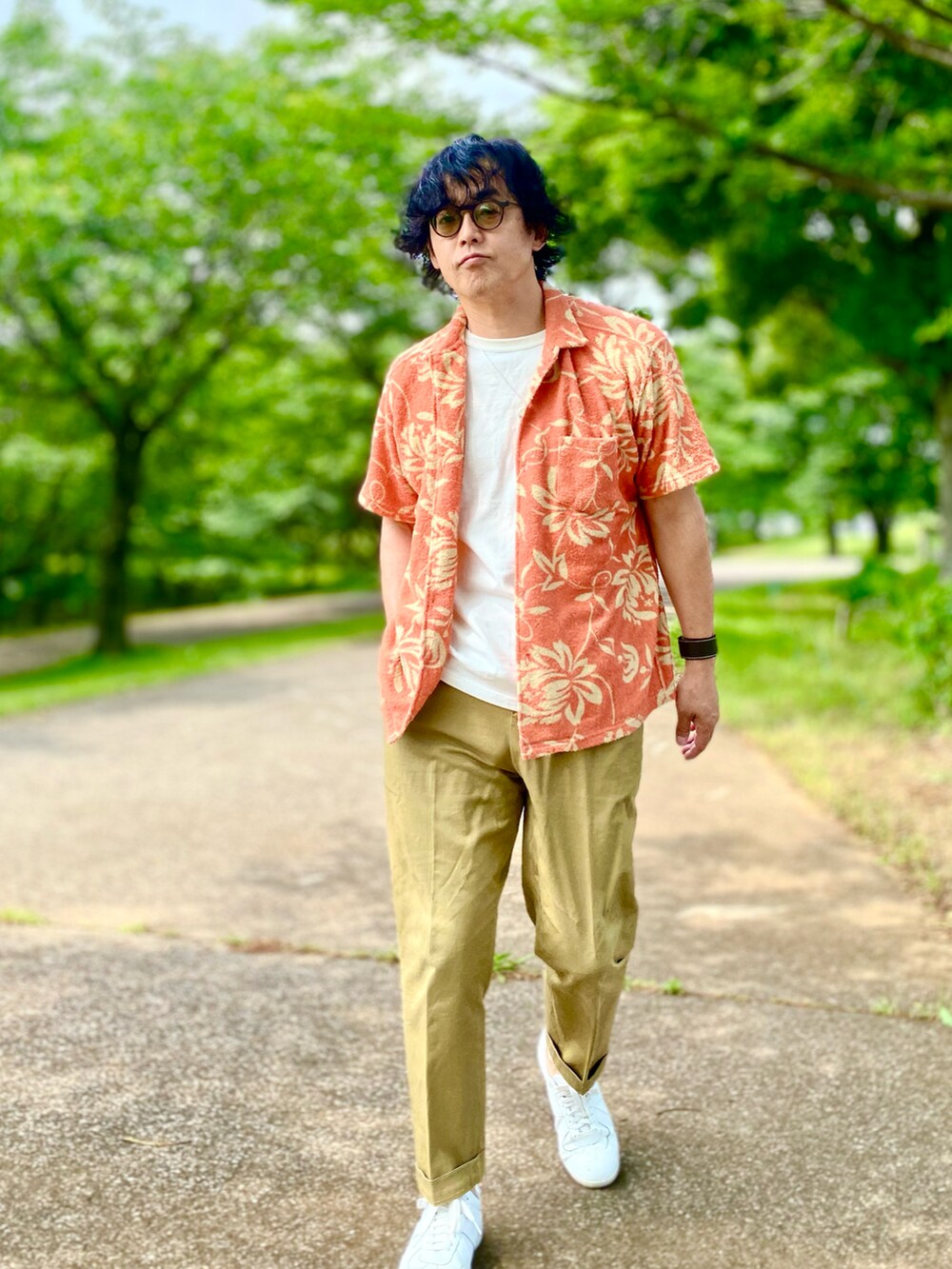 ベージュ系のチノパンツ、オレンジ系のシャツ/ブラウス、ホワイト系のTシャツ/カットソーを着用したメンズの夏コーディネートの2枚目の写真