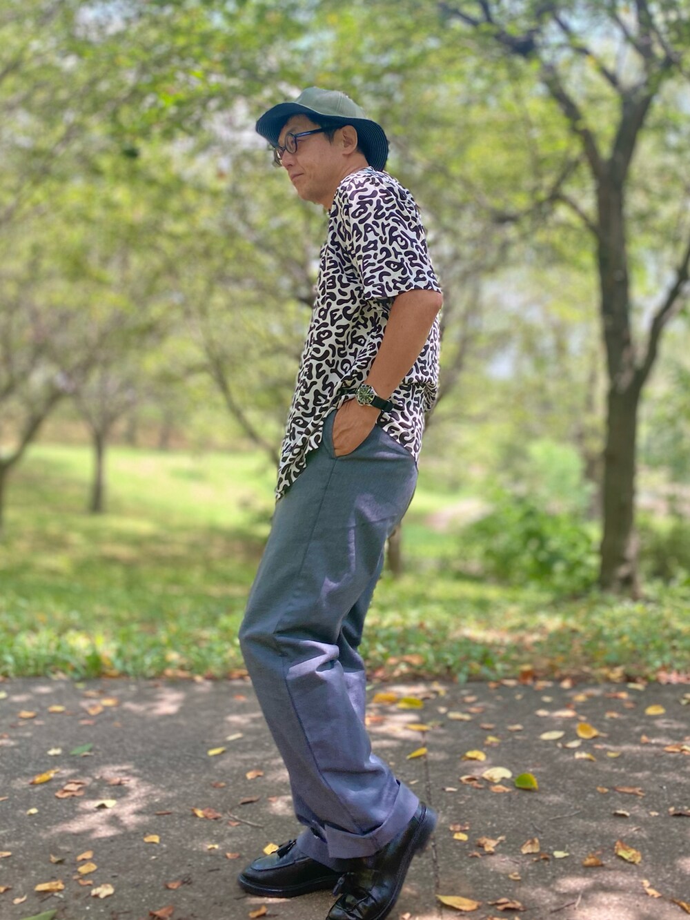 ホワイト系のシャツ/ブラウス、グレー系のその他パンツ、ブラック系のローファーを着用したメンズの夏コーディネートの2枚目の写真