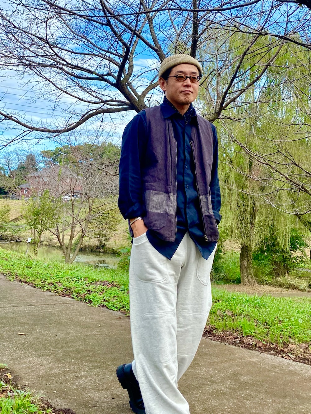 ホワイト系のスウェットパンツ、ブラック系のベスト、ホワイト系のニットキャップ/ビーニーを着用したメンズの秋コーディネートの4枚目の写真